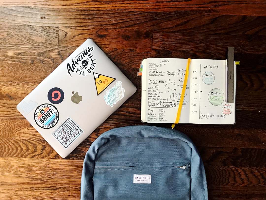 学生正在笔记本电脑上查看价格，背景是堆积的电脑组件